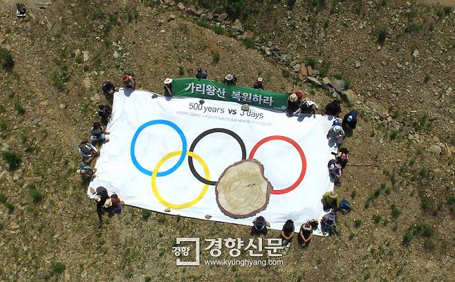 9일 산사태 위험이 커지고 있는 강원도 정선군 북평면 숙암리 가리왕산 알파인스키 경기장을 찾은 녹색연합 회원들이 대형 오륜기를 펼쳐 놓고 가리왕산 복원을 촉구하고 있다.   /정지윤기자