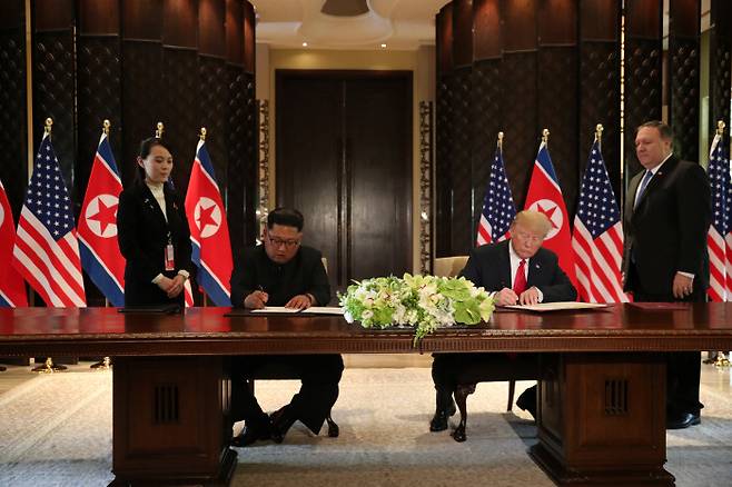 공동성명 서명 김정은 북한 국무위원장(왼쪽)과 도널드 트럼프 미국 대통령이 12일 싱가포르 카펠라호텔에서 첫 북·미 정상회담을 마친 뒤 공동성명에 서명하고 있다.  싱가포르 | 로이터연합뉴스
