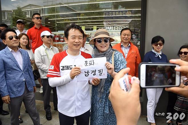 남경필 자유한국당 경기도지사 후보가 12일 한 여성 시민에게 '나는 문파다, 그래서 남경필을 지지한다'고 적힌 응원 메시지를 받으며 사진을 찍고 있다. 이 여성은 이어 '나는 여성이다, 그래서 남경필을 지지한다'는 응원메시지도 남 후보에게 건냈다. /사진제공=남경필 후보 캠프