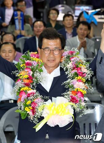 이시종 더불어민주당 충북도지사 후보가 13일 오후 충북 청주시 흥덕구 선거캠프에서 6·13 지방선거 당선이 확실시되자 꽃목걸이를 목에 걸고 손을 들고 있다.2018.6.13/뉴스1 © News1 김용빈 기자