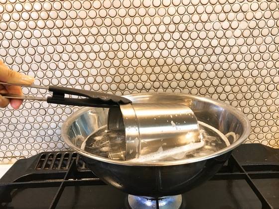 물이 끓었을 때 밖으로 넘치지 않을 정도로 물을 붓고 팔팔 끓이면서 수저통을 담근다. 집게로 수저통 입구를 잡고 돌돌 돌려준다.