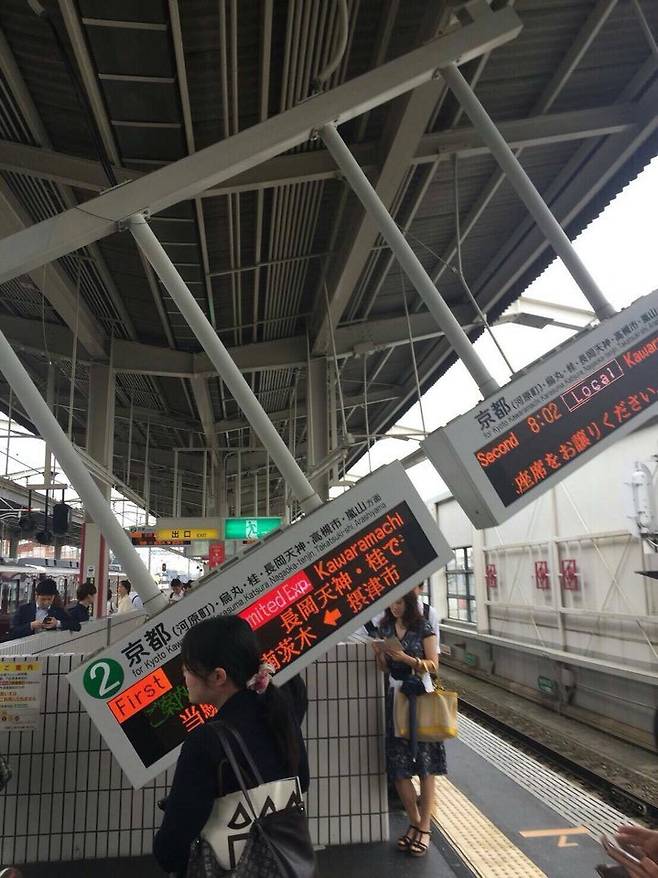 일본 오사카(大阪)를 비롯한 긴키(近畿) 지역에 규모 6.1의 지진이 발생한 가운데 이 지역 한 철도역의 안내판 일부가 떨어져 위험하게 공중에 매달려 있다. [연합뉴스]