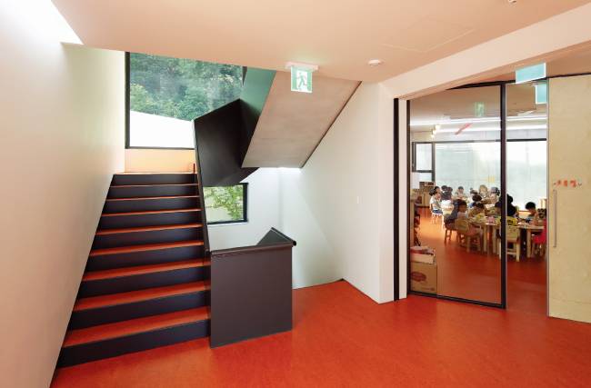 아이뜰유치원은 층별로 바닥 색깔을 달리했다. 현관으로 들어오면 만나게 되는 지하 1층은 공용공간으로 노랑, 지상 1~3층은 각각 5~7세 학급이 위치하는데 바닥색을 주황, 연두, 파랑으로 차별화했다. 사진은 5세 학급이 위치한 지상 1층. [김종호]