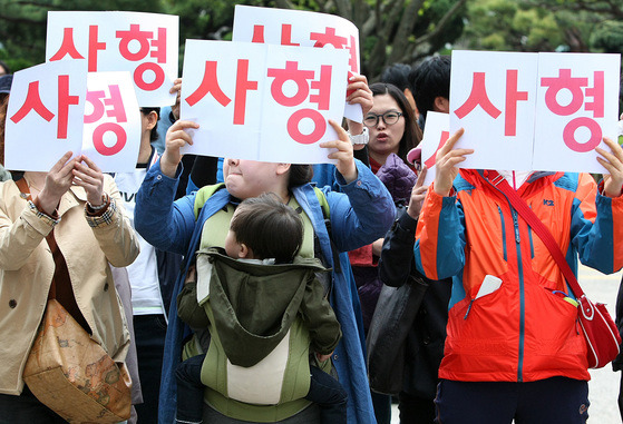 2014년 ‘경북 칠곡 의붓딸 사망 사건’에 대한 선고 공판 당시 어린이 관련 인터넷카페 회원들이 ‘사형’ ‘항소’ 등을 적은 종이를 들고 선고형량에 항의하는 시위를 벌이고 있다. 대구=프리랜서 공정식