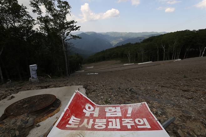 급경사면엔 붉은색으로 ‘위험! 토사붕괴 주의’라고 적힌 경고판이 바닥에 널브러져 있다.