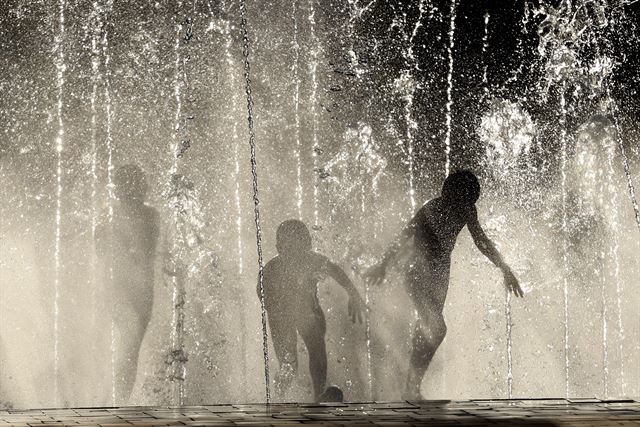35도가 웃도는 무더운 날씨를 보이고 있는 러시아 볼고그라드에서 21일(현지시간) 어린이들이 분수대에 뛰어들어 물놀이를 하며 더위를 식히고 있다. AP 연합뉴스