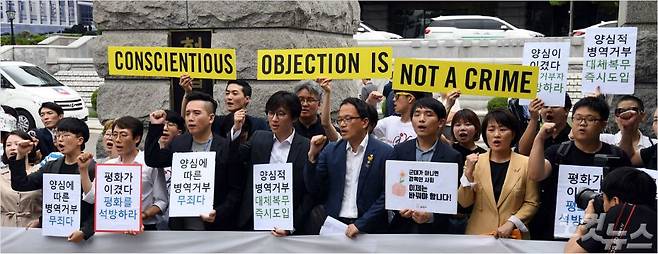 28일 오후 서울 종로구 헌법재판소 앞에서 ‘양심적 병역거부 관련 헌법재판소 결정에 대한 입장발표’ 기자회견 참석자들이 손피켓을 들고 구호를 외치고 있다.  헌재는 이날 병역법 제88조1항1호 등과 관련한 위헌법률심판 사건과 헌법소원심판 사건에서 재판관 4(합헌)대4(일부위헌)대1(각하) 의견으로 합헌 결정했다. 다만 병역의 종류를 5가지로 구분하면서 대체복무제를 포함하지 않는 병역법 제5조1항에 대해서는 재판관 6(헌법불합치)대 3(각하) 의견으로 헌법불합치 결정하면서 2019년 12월 31일까지 개정토록 촉구했다. 사진 중앙/박주민 더불어민주당 의원 (사진=황진환기자)