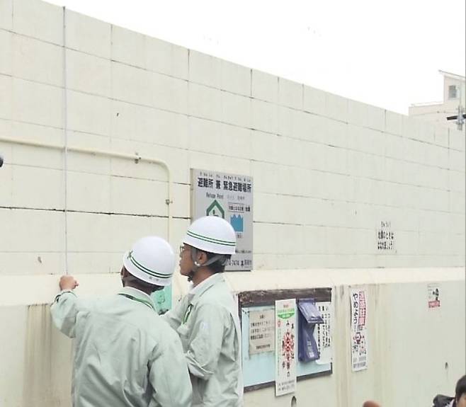 학교 외벽들을 점검하는 다카쓰키시 공무원들