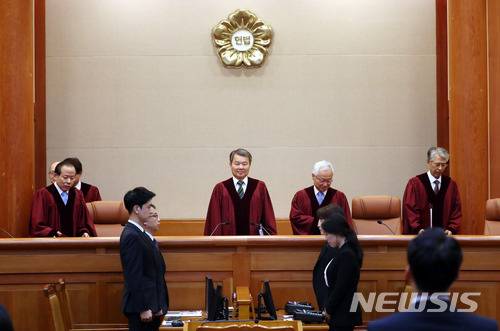 【서울=뉴시스】임태훈 기자 = 이진성 헌법재판소장을 비롯한 헌법재판관들이 28일 오후 서울 종로구 재동 헌법재판소 대심판정에서 열린 6월 심판사건 선고를 위해 자리로 이동하고 있다. 헌법재판소는 이날 “병역 의무도 중대한 공익이지만 개인의 양심적 자유도 중대한 가치”라며 병역거부 처벌조항인 병역법 88조 1항에 대해 합헌을 선고했다. 2018.06.28.   taehoonlim@newsis.com