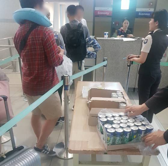 지난 1일 인천발 런던행 아시아나 여객기가 출발 시간이지연되자, 항공사측에서 탑승객들에게 음료수와 과자를 주고 있다. 함종선 기자