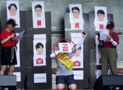 ‘곰’이라고 적힌 글자를 거꾸로 뒤집어들고 있는 한 참가자. 곰은 ‘문’을 뒤집어놓은 것으로 문재인 대통령에게 노무현 대통령 처럼 떨어져 죽으라는 의미로 남성혐오 사이트에서 자주 사용하는 글자다. [사진=온라인커뮤니티]