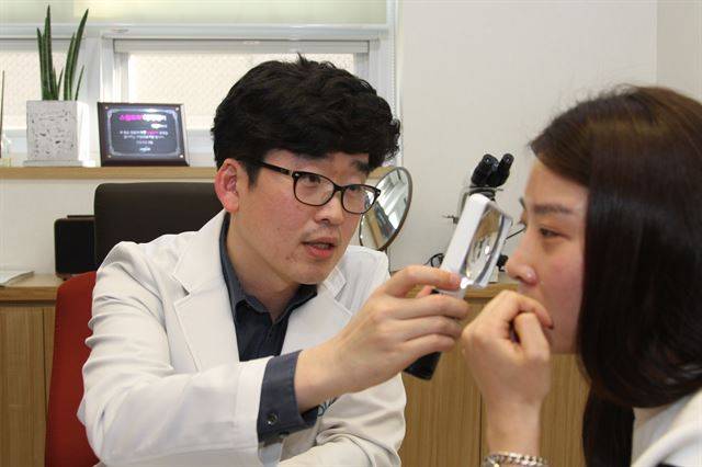 정홍대 피부과 전문의가 목에 쥐젖이 생긴 환자의 병변을 확인하고 있다. 애플피부과 제공.