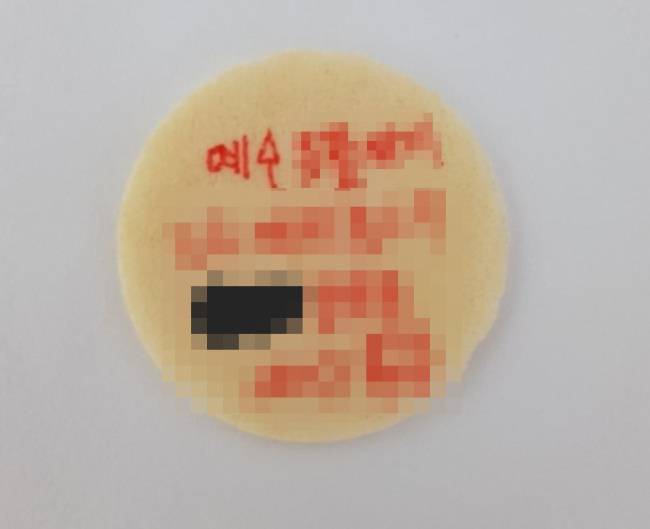 [사진=지난 10일 워마드 게시판에 올라온 성체 훼손 사진. 게시자는 성체에 빨간 글씨로 천주교를 비난하는 내용의 낙서를 하고 이를 올렸다.]