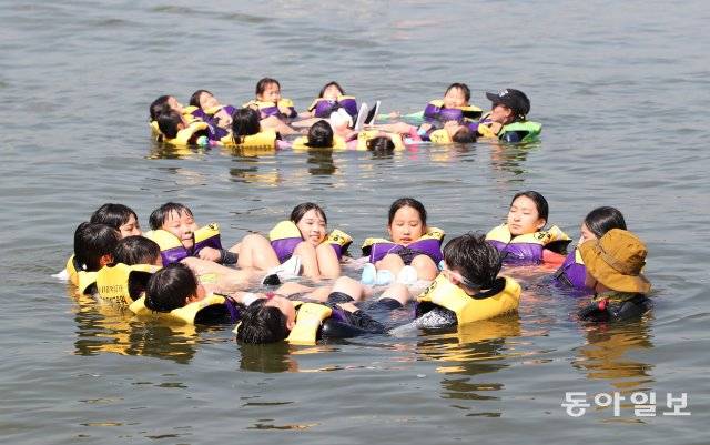 서울 잠실한강공원에서 열린 ‘안심 생존수영교육’에서 서울 명원초 학생들이 조난시 서로의 팔짱을 끼고 원을 만들어 체온을 유지하는 법을 배우고 있다. 김재명 기자 base@donga.com