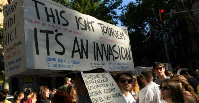 지난해 6월10일 스페인 바르셀로나에서 시위대가 정부 당국의 무분별한 관광객 유치를 비판하는 시위를 벌이고 있다. 프랑스24 홈페이지 캡처.