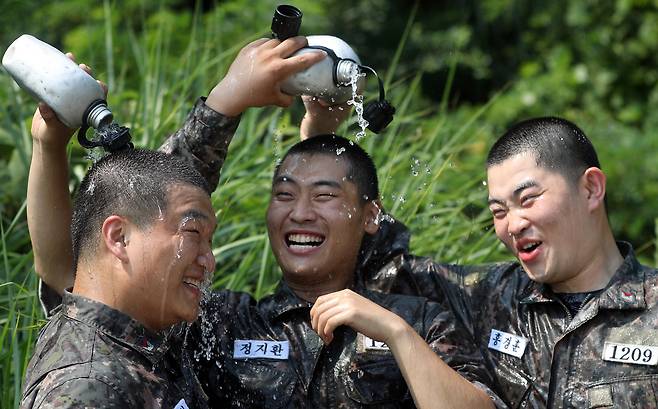 폭염 경보가 발효되었던 지난 18일 오후 경남 창원시 진해구 해군교육사령부 훈련장에서 훈련을 마친 부사관 후보생이 수통으로 물을 부으며 더위를 식히고 있다. [연합뉴스]