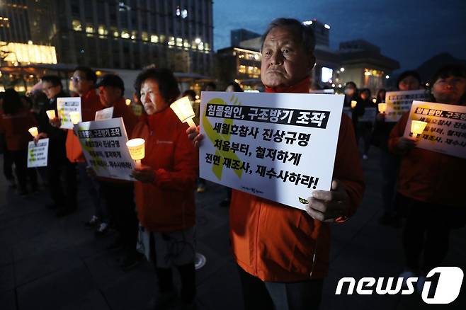스텔라데이지호 실종자 가족들이 지난 3월 서울 광화문광장에서 열린 '세월호 참사 구조 방기 규탄 긴급 촛불집회'에서 세월호 유가족들과 함께 촛불을 밝히고 있다. 이날은 스텔라데이지호가 남대서양에서 침몰한 지 1년이 되는 날이다. 2018.3.31/뉴스1 © News1 오대일 기자