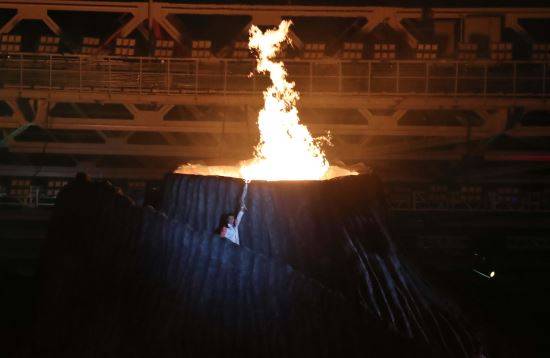 18일 인도네시아 자카르타 겔로라 붕 카르노 경기장에서 열린 2018 자카르타-팔렘방 아시안게임 개막식에서 인도네시아의 배드민턴 영웅이자 1992년 바르셀로나 올림픽 배드민턴 여자단식 금메달리스트인 수지 수산티가 성화에 불을 붙이고 있다.