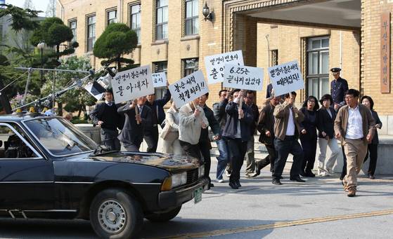 영화 '변호인'에서 송우석(송강호) 변호사가 진우(임시완)을 변호하기 위해 차를 몰고 법원으로 들어오던 중 시위대를 만나는 장면. [사진 대전정보문화산업진흥원]