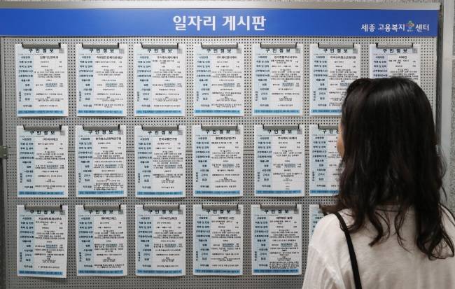 A young Korean woman reads about job openings at a labor office in Seoul. (Yonhap)