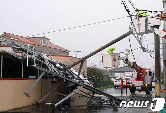 태풍 솔릭이 제주를 통과한 23일 제주시 삼양소규모노인종합센터 옥상에 있던 태양광판이 강풍에 휩쓸려 아래로 떨어지면서 전봇대가 부러지고 인근 주택을 덮쳤다.2018.8.23/뉴스1 © News1 고동명 기자