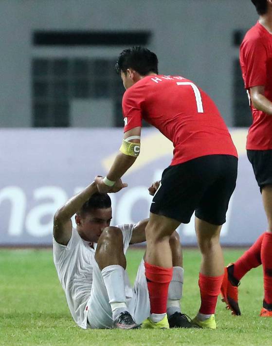 손흥민이 이란 선수를 일으켜 주고 있다. 김성룡 기자