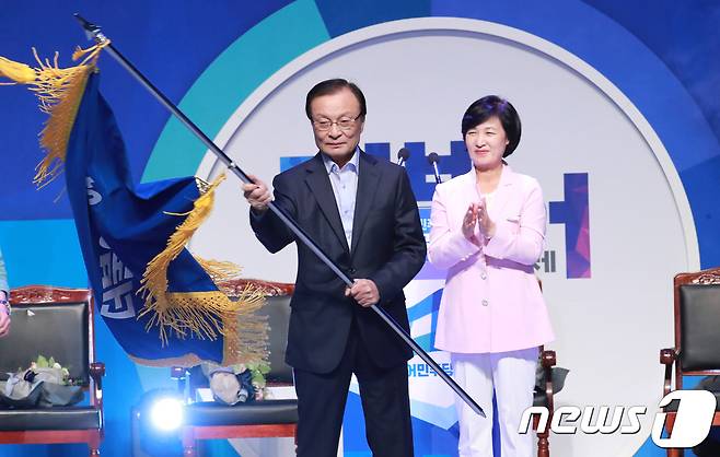이해찬 더불어민주당 신임 당대표가 25일 오후 서울 송파구 방이동 올림픽공원 체조경기장에서 열린 더불어민주당 당대표 및 최고위원 선출을 위한 제3차 정기 전국대의원대회에서 당 대표로 선출 된 후 당기를 흔들고 있다.  © News1 이동원 기자