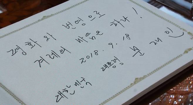 문 대통령의 방명록 문재인 대통령이 18일 오후 북한 김정은 국무위원장과의 정상회담 장소인 평양 조선노동당 중앙위원회 본부 청사를 방문해 방명록에 ‘평화와 번영으로 겨레의 마음은 하나!’라고 썼다.  평양사진공동취재단·서성일 기자