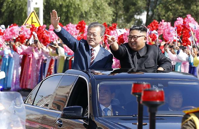 ▲ 문재인 대통령과 김정은 국무위원장이 무개차를 타고 18일 평양순안공항에서 백화원 초대소로 이동하며 시민들을 향해 인사하고 있다. 사진=평양사진공동취재단