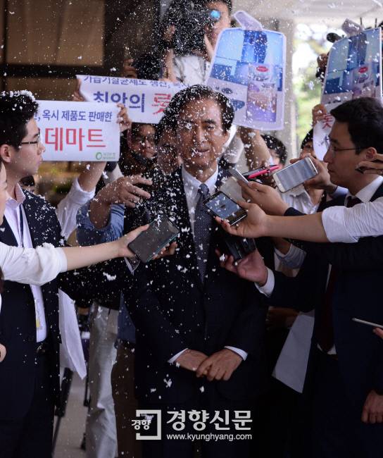 노병용 롯데마트 전 대표(현 롯데물산 대표)가 2일 가습기 살균제 사망 사건과 관련해 피의자 신분으로 검찰에 출석하던 중 피해자와 환경단체 회원들이 뿌린 인공 눈을 맞고 있다.    / 서성일 기자 centing@kyunghyang.com