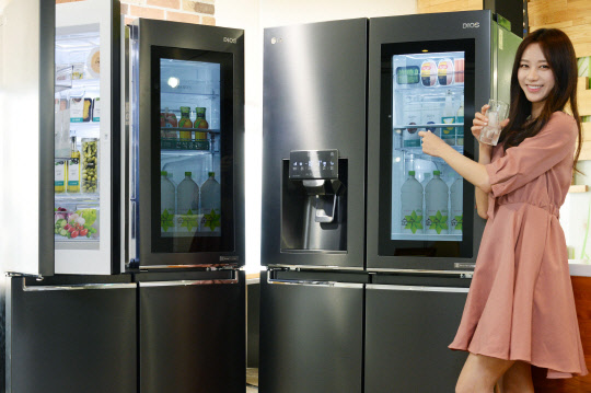 LG전자는 노크온 매직스페이스를 적용한 870ℓ 더블매직스페이스냉장고(왼쪽)와 824ℓ 얼음정수기냉장고(오른쪽) 신제품을 각각 선보였다고 26일 밝혔다. 모델이 신제품을 소개하고 있다.  LG전자 제공