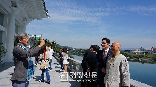 유홍준 명지대 석좌교수가 대동강을 배경으로 이재용 삼성전자 부회장과 원택 조계종 민족공동체추진본부장의 사진을 찍어주고 있다. 청와대 제공