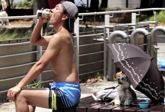 일본에 섭씨 35도의 무더위가 기승을 부렸던 지난 7월 9일 도쿄 다이바공원에서 음료수를 마시는 남성 자료사진. AP뉴시스
