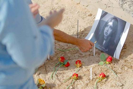 타라 파레스의 팬이 그가 묻힌 곳에서 기도하며 추모하는 모습. [AP=연합뉴스]