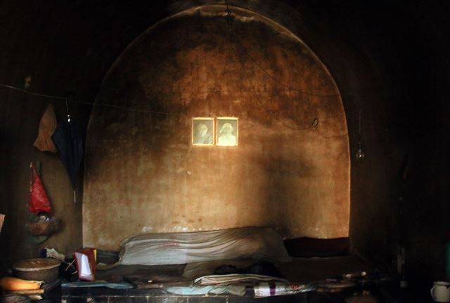 노부부의 초상화가 나란히 걸려 있는 동굴집 내부.