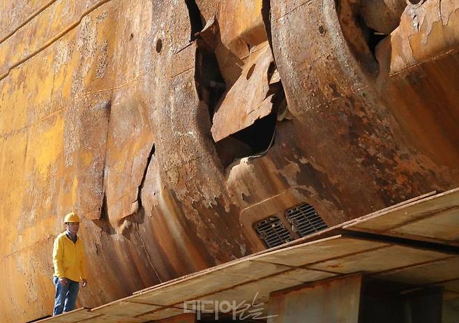 ▲ 정성욱 선체인양분과장이 19일 세월호 좌현에 위치한 2개의 외부 충돌 흔적 앞에 서 있다. 사진=김예리 기자