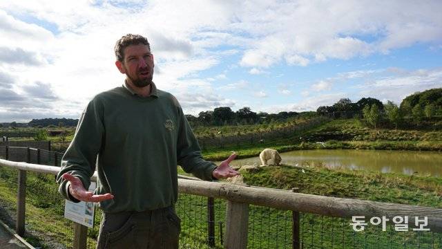 지난달 3일 영국 동캐스터의 요크셔 야생동물공원(YWP)에서 북극곰 사육사 사이먼 마시 씨가 북극곰 사육지인  프로젝트 폴러 를 소개하고 있다.  그의 뒤로 고기를 먹는 북극곰이 보인다. 동캐스터=서형석 기자 skytree08@donga.com