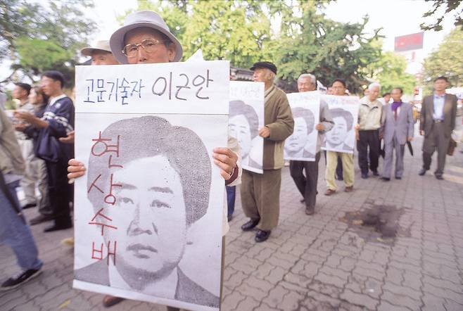 1990년대 중반 민주화실천가족운동협의회(민가협) 목요집회에 참석한 장기수 할아버지들이 도주 중인 고문기술자 이근안에 대한 수사를 촉구하고 있다. <한겨레> 자료사진