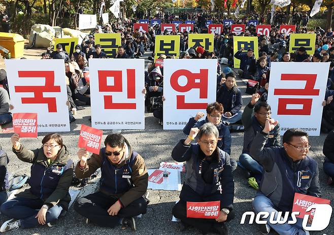 30일 서울 영등포구 여의도 산업은행 일대에서 열린 국민연금 개혁 사회안전망 쟁취 결의 대회에서 민주노총 노조원들이 구호를 외치고 있다. 이날 결의대회에서 민주노총은 국민연금개혁과 사회안전망 강화, 비정규직의 제대로 된 정규직 전환 등을 촉구 했다. 2018.10.30/뉴스1 © News1 송원영 기자