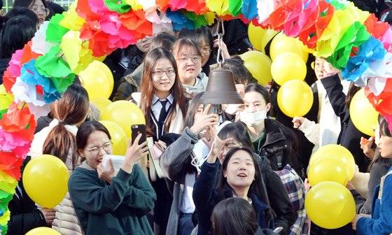 14일 오전 광주 남구 설월여자고등학교 3학년 학생들이 후배들의 응원을 받으며 '수능대박 종'을 치고 있다. [뉴스1]