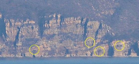 14일 오전 백령도 심청각에서 바라본 북쪽 장산곳 갱도 진지. 일부는 여전히 포구가 열려 있다. 국방부는 "군사합의서 문구를 그대로 이해해달라"며 "9ㆍ19 군사합의서에 따라 해안포 포문은 모두 폐쇄됐다"고 설명했다. [사진 박용한]