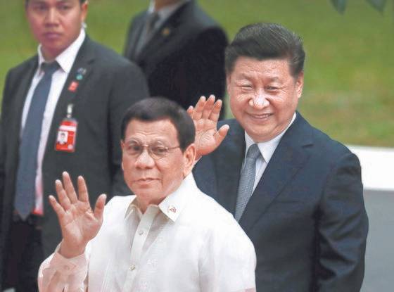 필리핀을 방문한 시진핑 중국 국가주석(오른쪽)이 20일(현지시간) 마닐라 마라카낭 궁에서 두테르테 필리핀 대통령과 함께 손을 흔들고 있다. [로이터=연합뉴스]