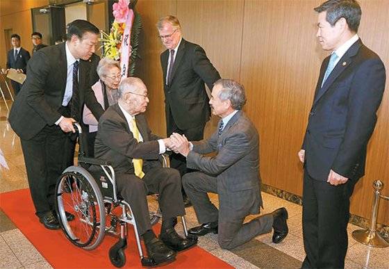 6·25전쟁 영웅으로 불리는 백선엽(예비역 대장) 장군의 99세 생일 행사가 21일 서울 용산 국방컨벤션에서 열렸다. 해리 해리스 주한 미국대사가 휠체어에 탄 백 장군에게 무릎을 꿇은 채 인사하고 있다. [뉴시스]