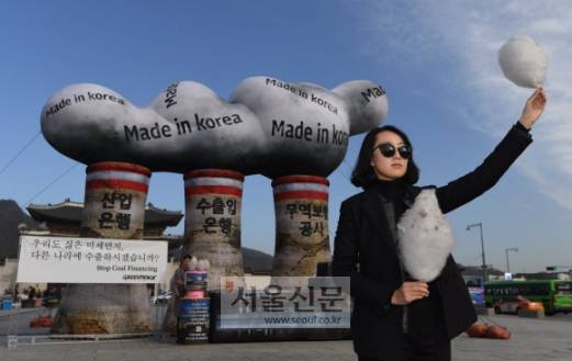 미세먼지 위험성 알리는 회색 솜사탕 시위  - 국제환경단체 그린피스 회원이 28일 서울 종로구 광화문 광장에 설치된 석탄발전소 모형 앞에서 미세먼지의 위험성을 알리기 위해 이를 본떠 만든 회색 솜사탕을 들고 있다. 그린피스 서울사무소는 지난 9월부터 산업은행과 수출입은행을 포함한 한국 금융기관의 해외 석탄발전소 투자 중단을 촉구하는 캠페인도 진행하고 있다. 박윤슬 기자 seul@seoul.co.kr