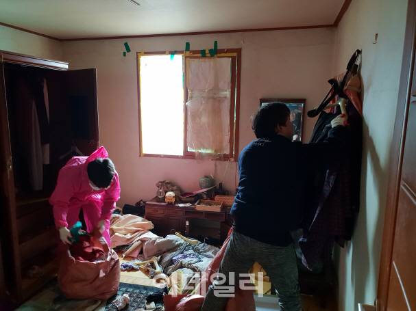 본지 신중섭 기자가 특수청소업체 직원과 함께 유품정리를 하고 있다.