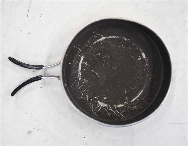 코팅이 벗겨지다 못해 흠집이 심하게 난 캠핑용 프라이팬.
