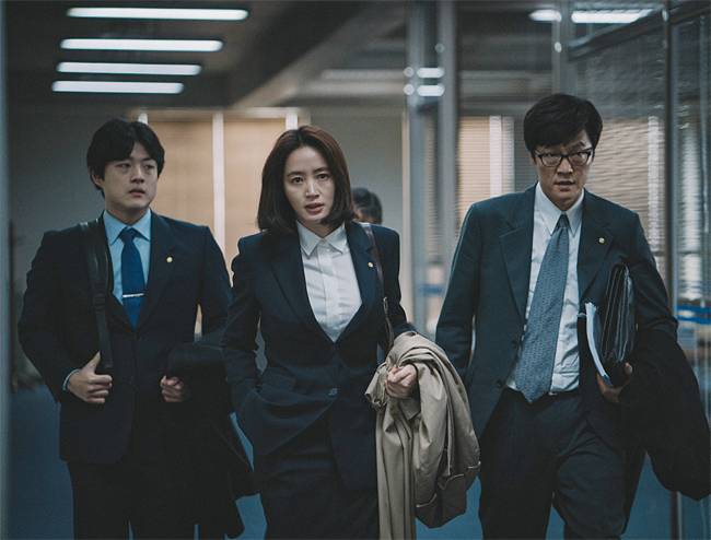 영화 속에서 주인공 한시현(김혜수·가운데)은 무너지는 경제를 어떻게든 살리려고 한다. 사진 CJ엔터테인먼트