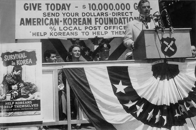한국전쟁 당시 주한 미8군 사령관을 지낸 제임스 밴플리트 장군이 1954년 뉴욕에서 한국에 1000만 달러의 구호물자를 보내자고 호소하고 있다. 왼쪽에 한국 고아들의 모습을 담아 원조를 호소한 포스터가 보인다. [중앙포토, 도서 한국전쟁]