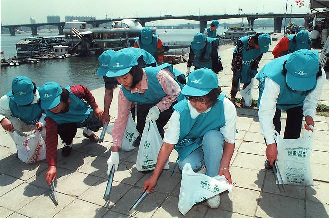 1995년 5월 한강물맑히기운동에 참여한 서울시내 주부 환경봉사단 500 여명이 여의도 고수부지 선착장에서 쓰레기를 줍고 있다.[중앙포토]