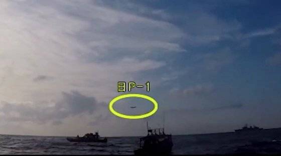 국방부가 4일 한일 '레이더 갈등' 일본 측 주장을 반박하는 동영상을 유튜브에 공개했다.   사진은 조난 선박 구조작전 중인 광개토대왕함 상공에 저고도로 진입한 일본 초계기 모습(노란 원)으로 해경 촬영 영상이다. [연합뉴스,국방부 유튜브 캡처]